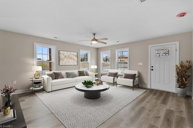 living room featuring baseboards, plenty of natural light, and wood finished floors