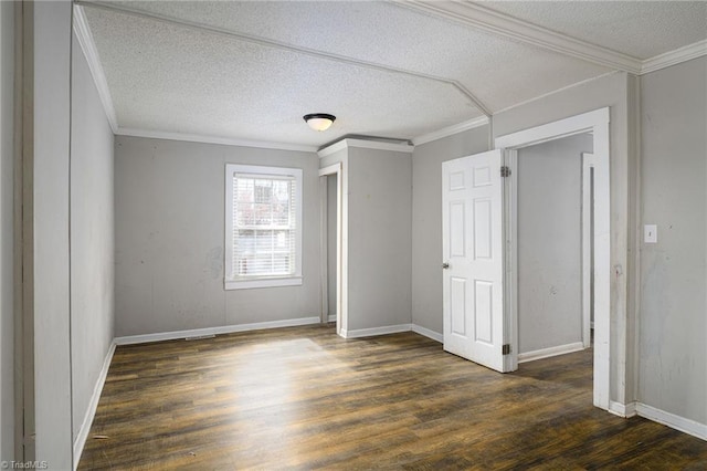 unfurnished bedroom featuring ornamental molding, a textured ceiling, baseboards, and dark wood-style floors