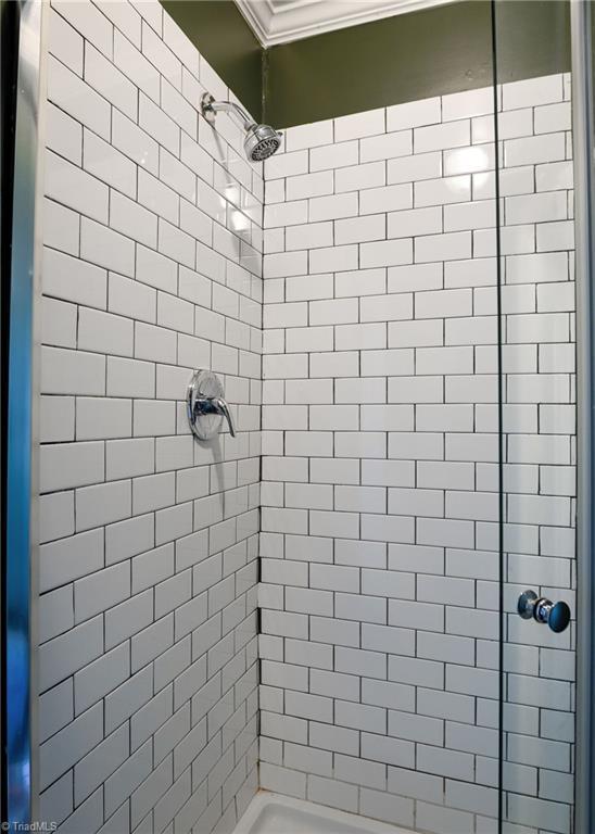 full bathroom featuring a stall shower and ornamental molding