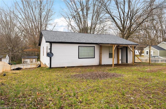 view of front of property with fence, a front lawn, and roof with shingles