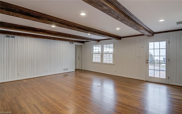 empty room with beamed ceiling, wood-type flooring, and wood walls