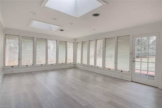 unfurnished sunroom featuring a skylight