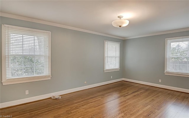 empty room with crown molding and hardwood / wood-style flooring