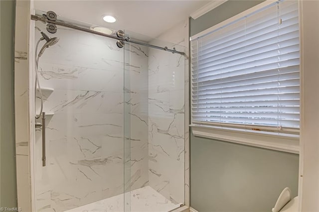 bathroom with ornamental molding and a shower with door