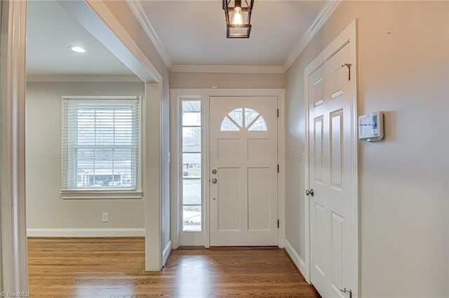 foyer entrance with ornamental molding and light hardwood / wood-style floors