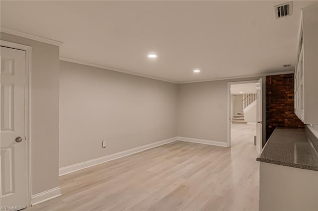 interior space featuring crown molding and light hardwood / wood-style flooring