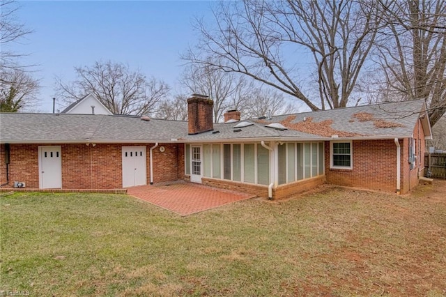 back of property featuring a patio area, a sunroom, and a lawn