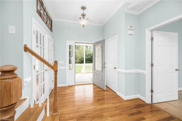 entrance foyer with ornamental molding and light wood-type flooring