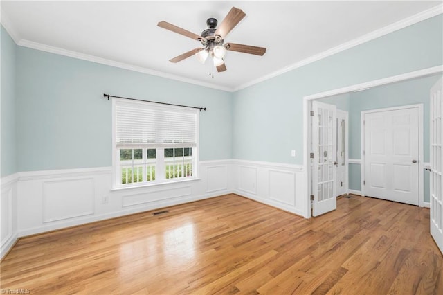 spare room with light wood-type flooring, crown molding, and ceiling fan