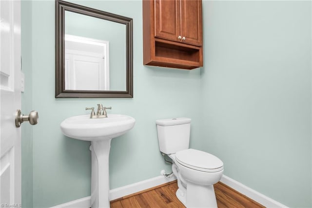 bathroom featuring hardwood / wood-style flooring and toilet