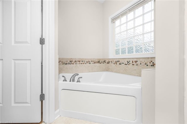 bathroom with a tub to relax in, tile walls, and tile patterned flooring