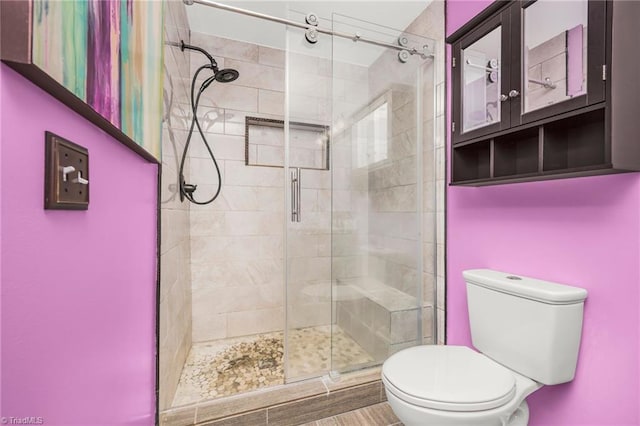 bathroom featuring toilet and an enclosed shower