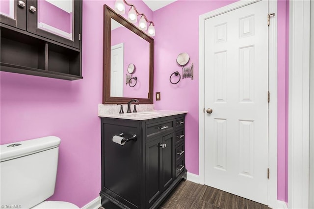 bathroom featuring vanity, toilet, and hardwood / wood-style flooring