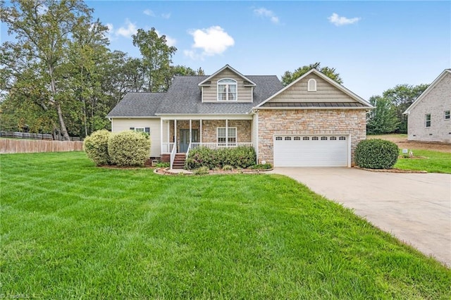 view of front of property featuring a front lawn, covered porch, and a garage