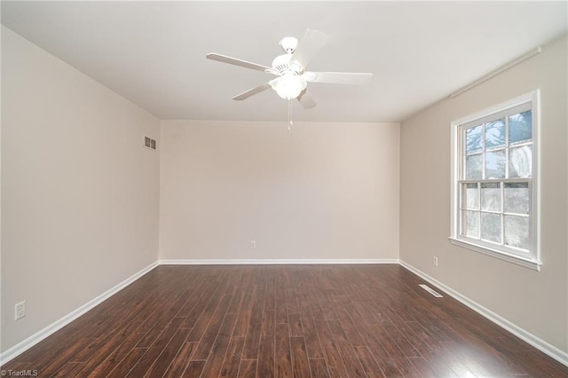 unfurnished room featuring visible vents, baseboards, dark wood finished floors, and a ceiling fan