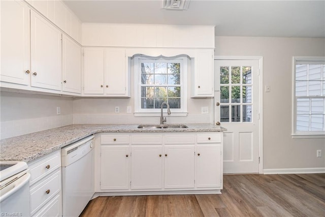 kitchen featuring white appliances, white cabinetry, and a sink