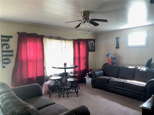 living room with crown molding, carpet floors, plenty of natural light, and a ceiling fan