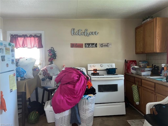 kitchen featuring a sink, brown cabinets, and white appliances
