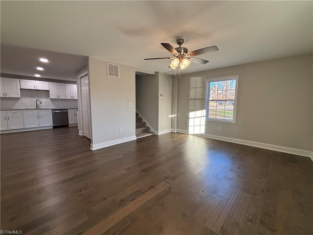 unfurnished living room featuring ceiling fan, dark hardwood / wood-style flooring, and sink