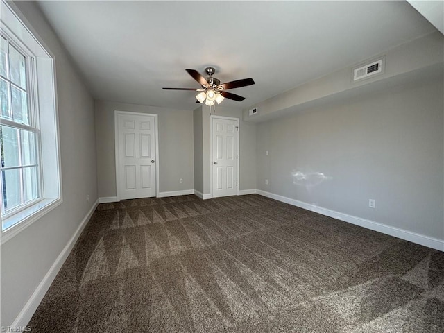 unfurnished bedroom featuring carpet flooring, multiple windows, and ceiling fan