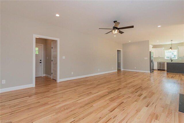 unfurnished living room featuring light wood-type flooring, a ceiling fan, baseboards, and recessed lighting