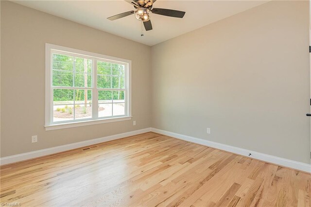 empty room with baseboards, ceiling fan, and light wood-style flooring