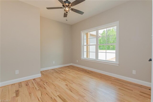 empty room with baseboards, light wood finished floors, and ceiling fan