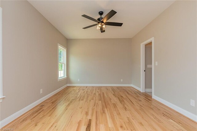 unfurnished room featuring a ceiling fan, baseboards, and light wood finished floors