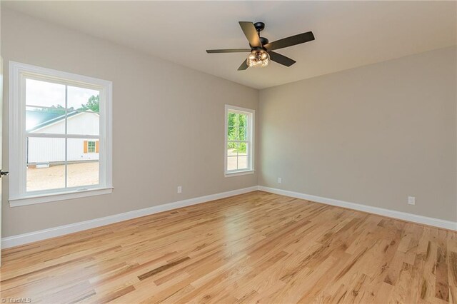 empty room featuring light wood-type flooring, baseboards, and ceiling fan