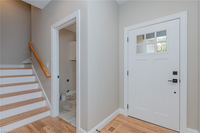 foyer featuring stairway, baseboards, and light wood-style flooring