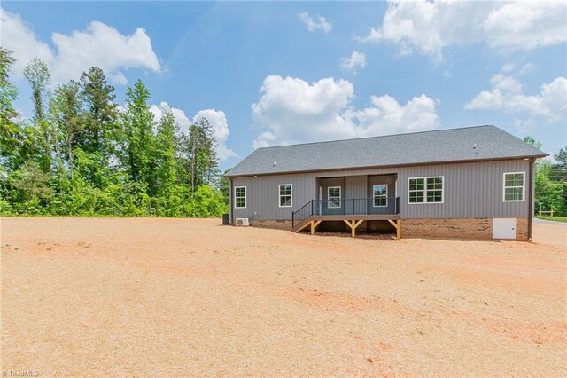 back of property with crawl space, stairs, roof with shingles, and a deck