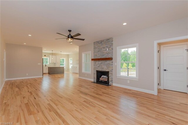 unfurnished living room featuring baseboards, a ceiling fan, and light wood-type flooring