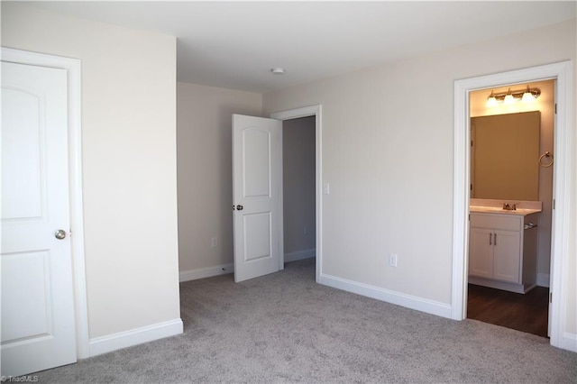 unfurnished bedroom with sink, light colored carpet, and ensuite bathroom