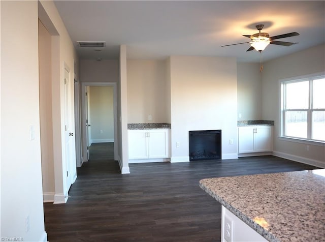 living room featuring ceiling fan and dark wood-type flooring