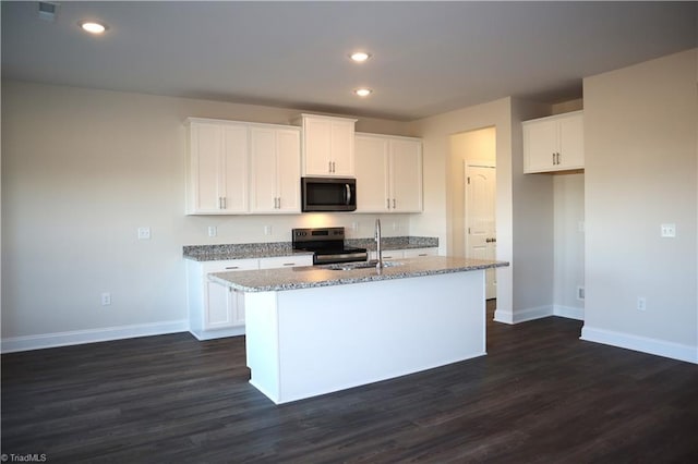 kitchen featuring white cabinets, appliances with stainless steel finishes, dark hardwood / wood-style flooring, and an island with sink