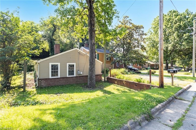 608 Spruce St, High Point, NC 27262 - view of property exterior featuring a lawn, a chimney, and brick siding