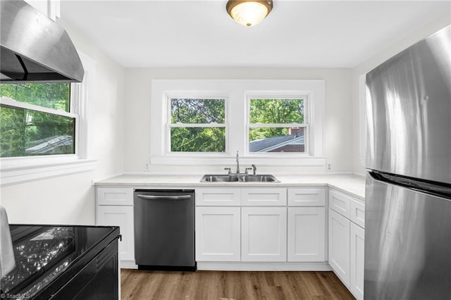 608 Spruce St, High Point, NC 27262 - kitchen featuring stainless steel appliances, range hood, white cabinetry, wood finished floors, and light countertops