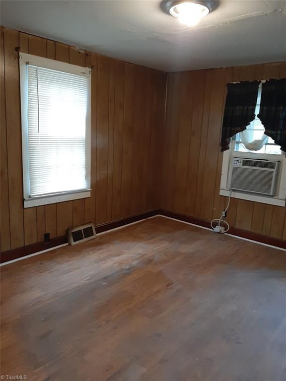 spare room featuring wood walls, cooling unit, and hardwood / wood-style flooring