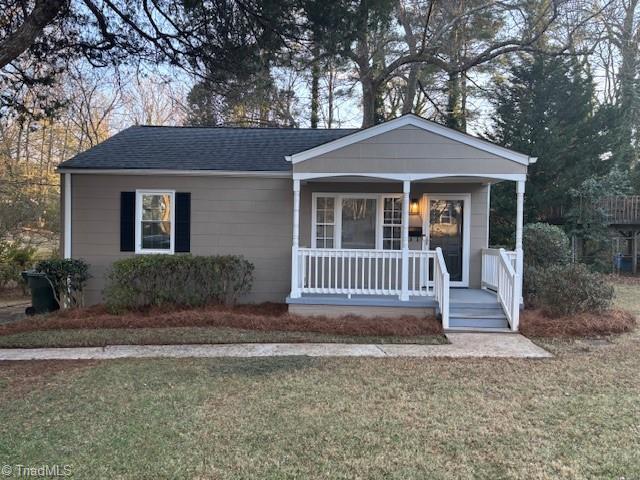 view of front of property featuring covered porch and a front lawn