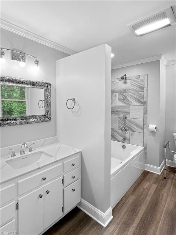 full bathroom with crown molding, toilet, baseboards, and wood finished floors