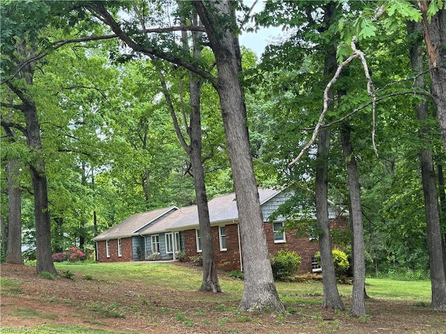 single story home featuring brick siding and a front yard