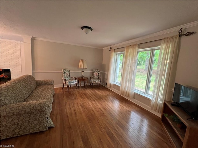 living area featuring baseboards, ornamental molding, and wood finished floors