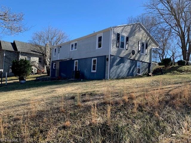 rear view of property with a yard and central AC unit