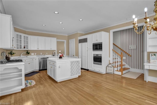 1902 Rockglen Ln, Greensboro, NC 27410 - kitchen featuring appliances with stainless steel finishes, light wood-style floors, a chandelier, light countertops, and white cabinets
