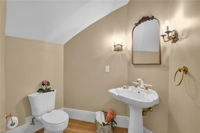 bathroom with hardwood / wood-style floors, lofted ceiling, and toilet