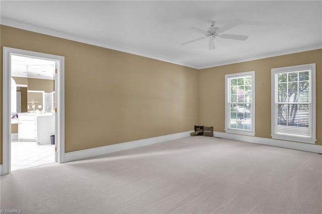 empty room featuring crown molding, ceiling fan, and light colored carpet