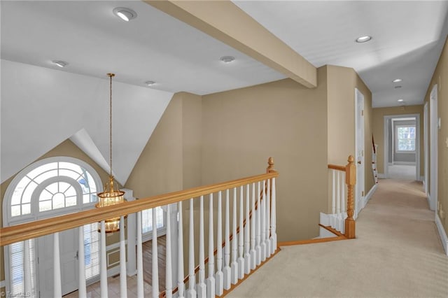 corridor featuring light colored carpet and a chandelier