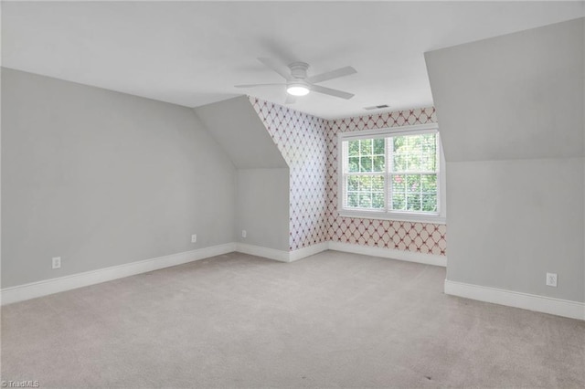 additional living space with light carpet, vaulted ceiling, and ceiling fan