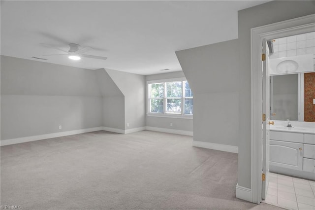 additional living space with sink, ceiling fan, and light colored carpet