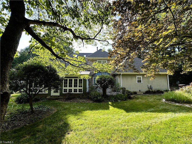 back of house with a lawn